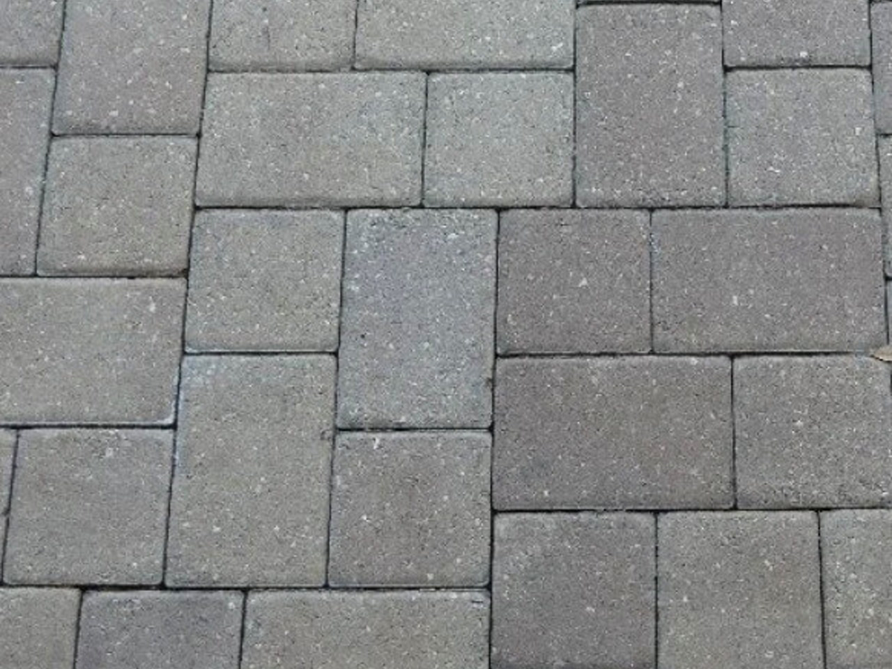 Gray concrete paver driveway in a tumbled modular pattern