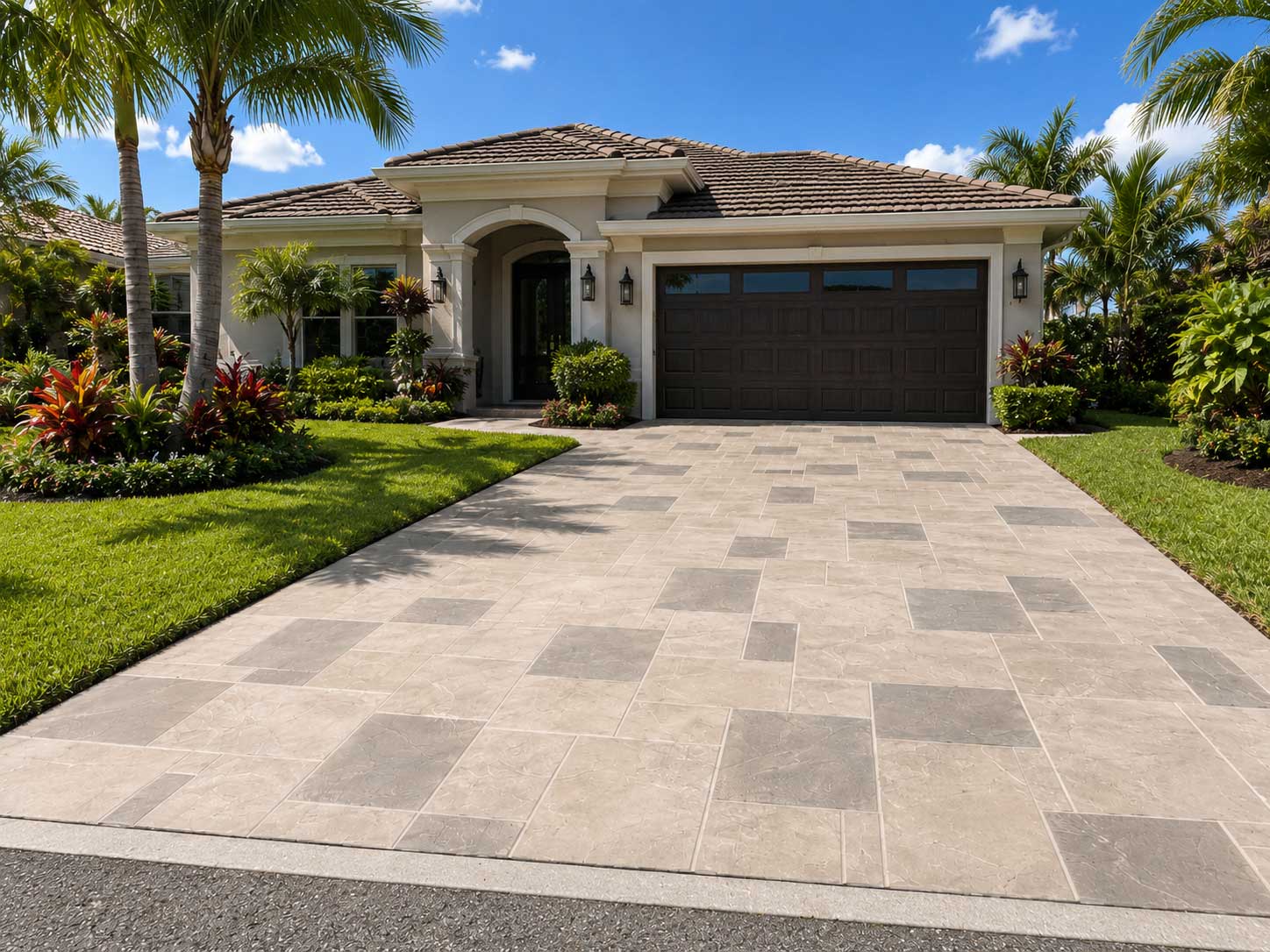 Modern driveway paved with rectangular stone pavers in front of a tropical home