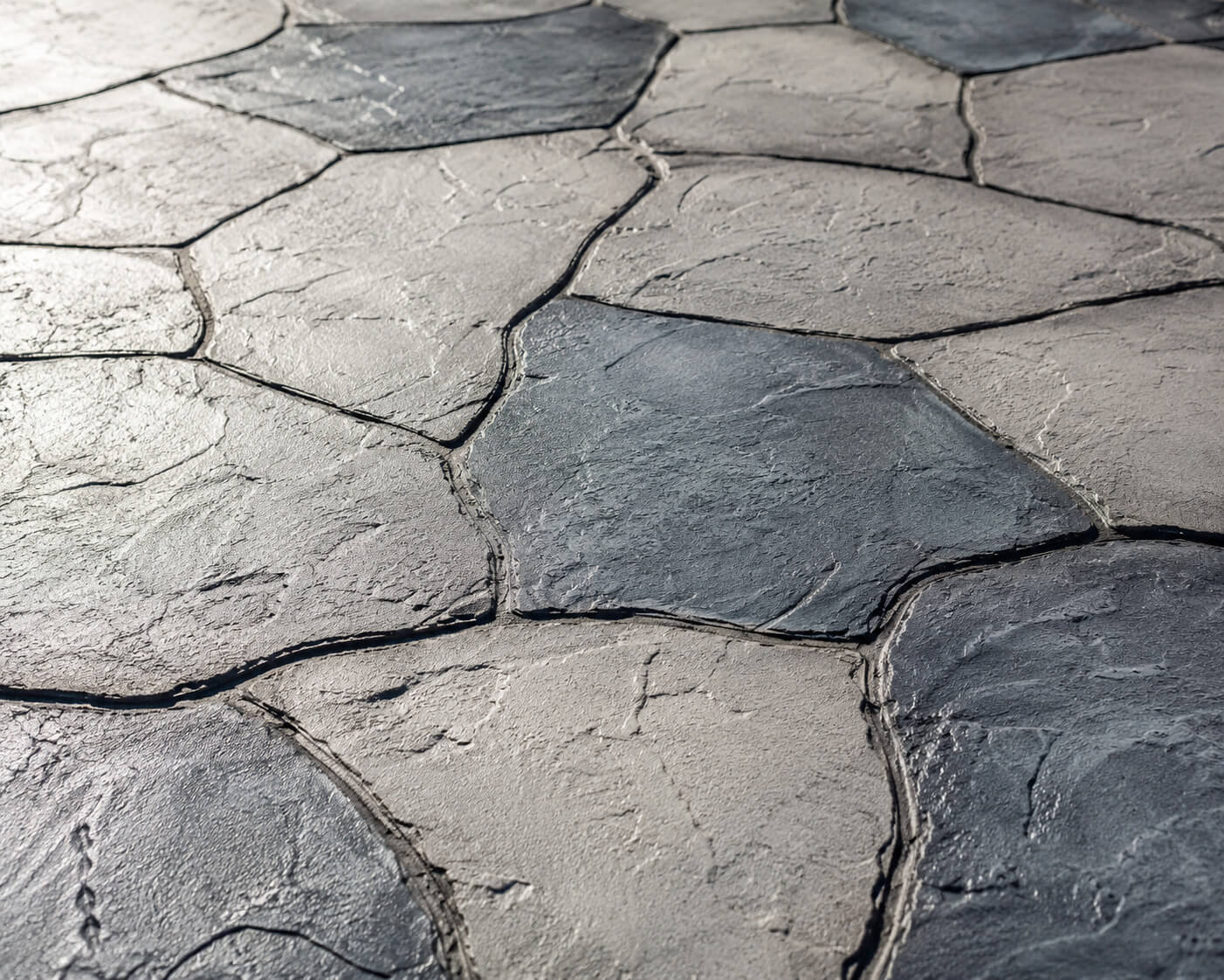 Gray stamped concrete overlay pool deck with an irregular flagstone pattern